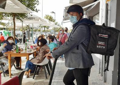 Imagen secundaria 1 - Terraza de la playa de la Malvarrosa, reparto a domicilio del restaurante Hermanos Barberá y terraza de un bar. 