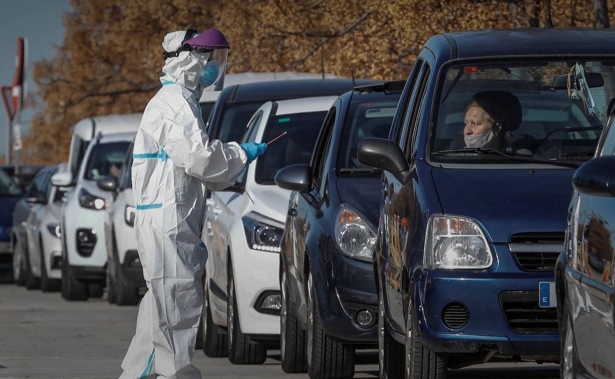 Un sanitario con equipo de protección realiza pruebas PCR frente al hospital La Fe.