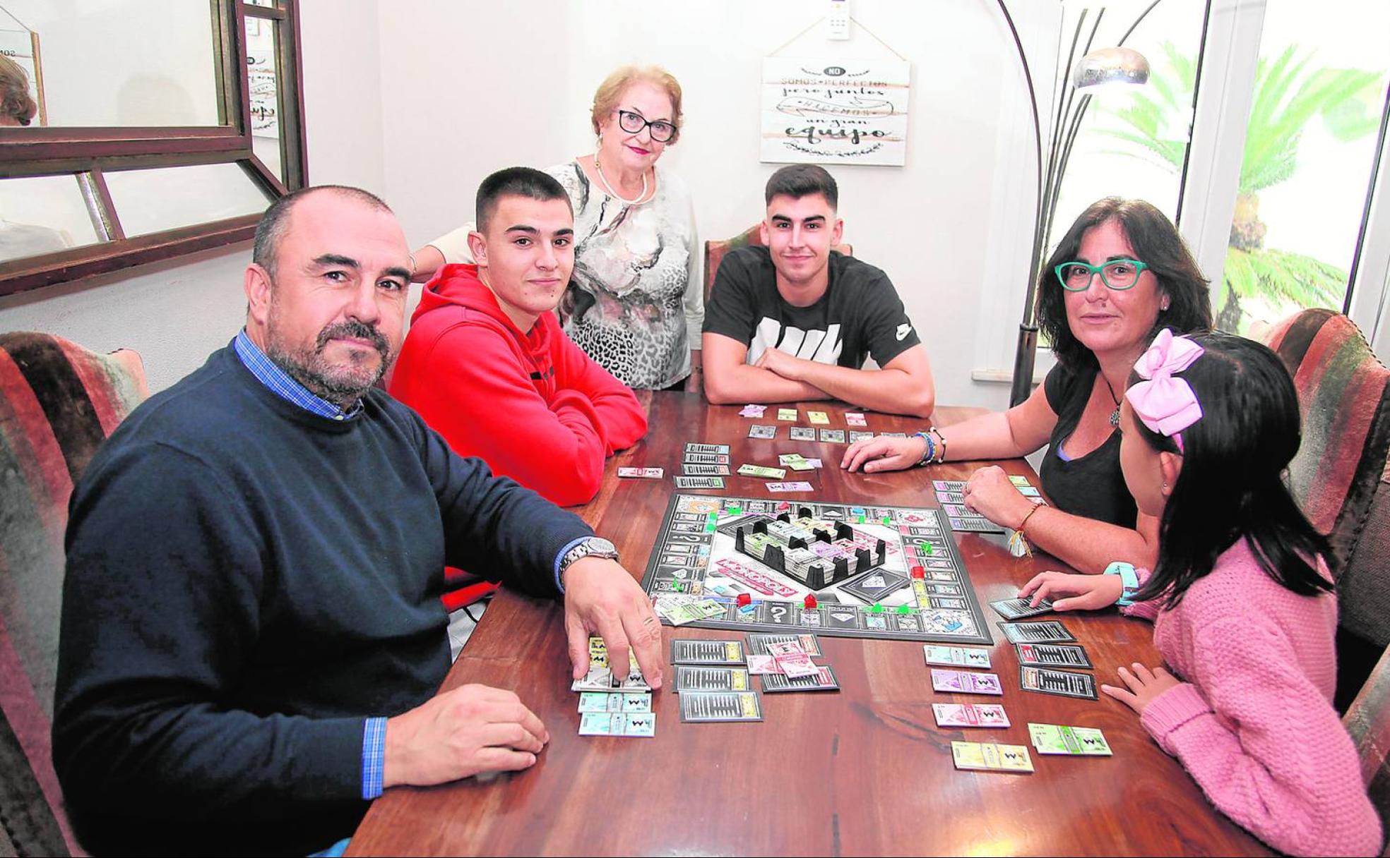 Todos juntos. La familia Ots Mut reunida en su casa en torno a un juego de mesa.