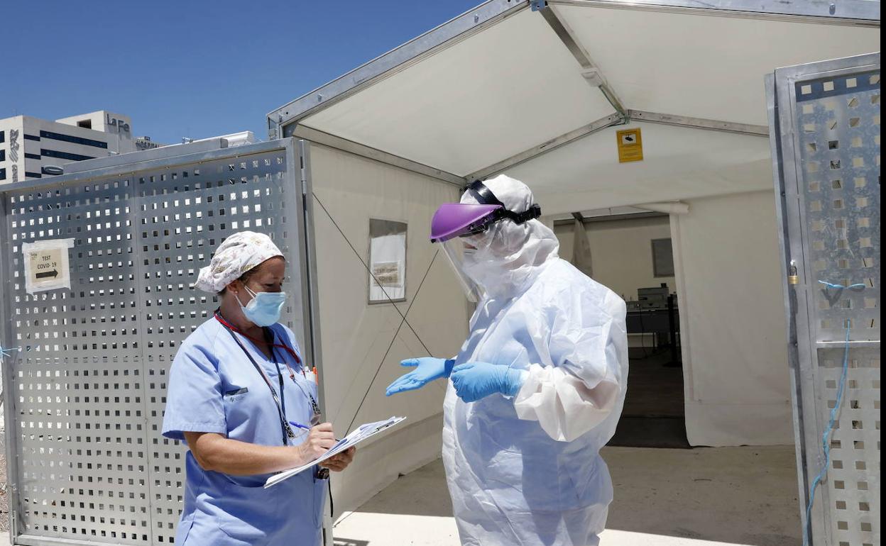 Dos sanitarios, en la puerta del hospital de campaña situado junto a La Fe. 