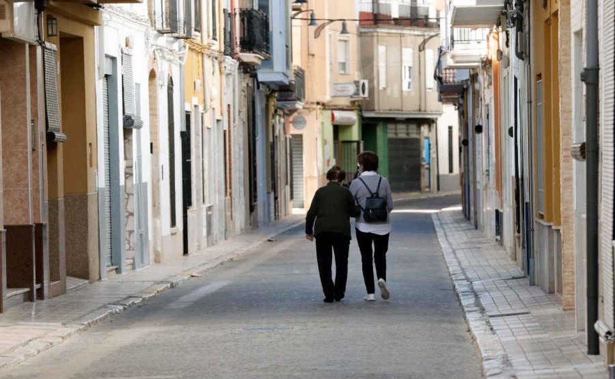 Dos personas pasean por la calle de un municipio valenciano durante la pandemia.