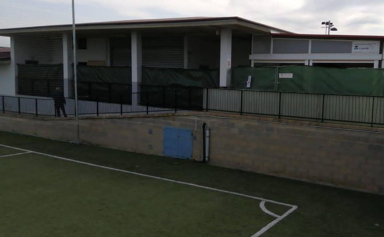 El terreno de juego rodeado por una malla verde que impide la visión desde el bar. 