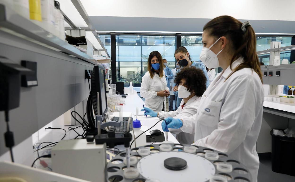 Especialistas de Global Omnium trabajan en el laboratorio durante la visita de la consellera Mireia Mollà, ayer. 