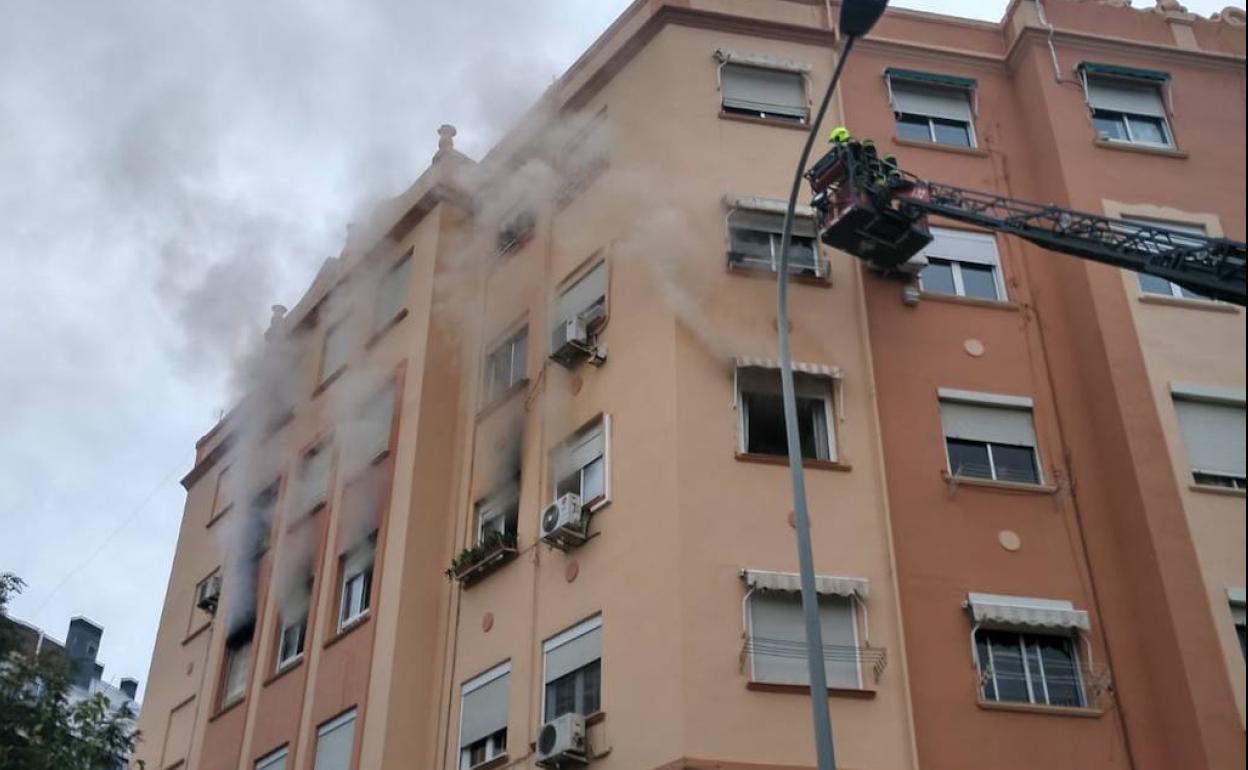 Los bomberos intervienen en la vivienda en llamas.