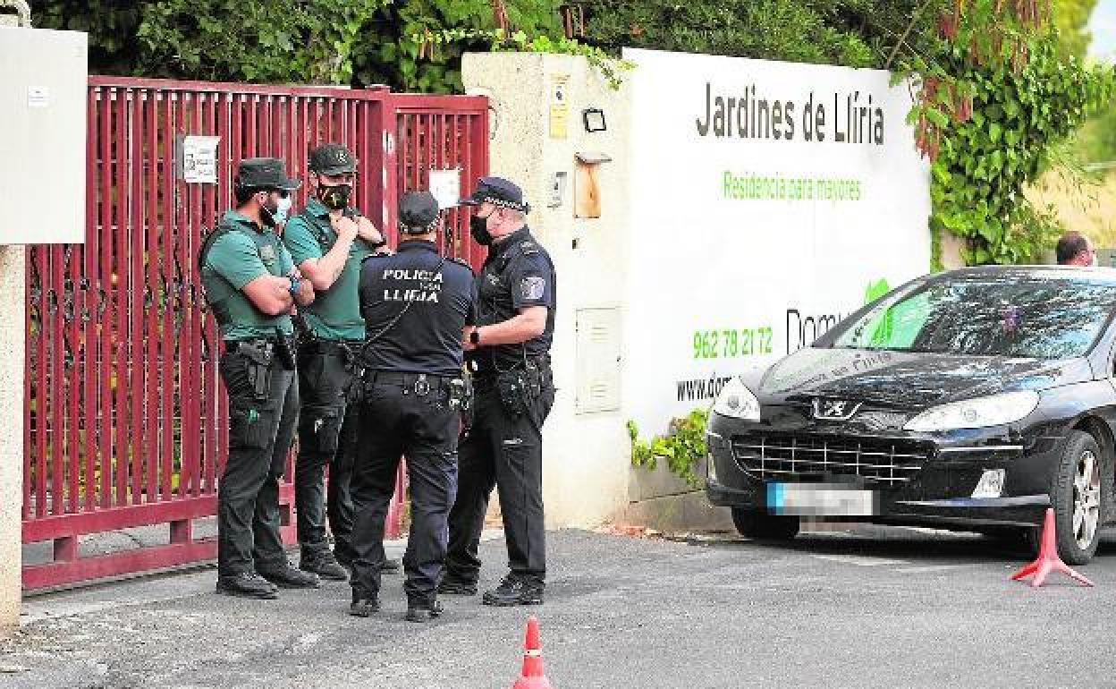 Agentes, en la puerta de la residencia investigada. 