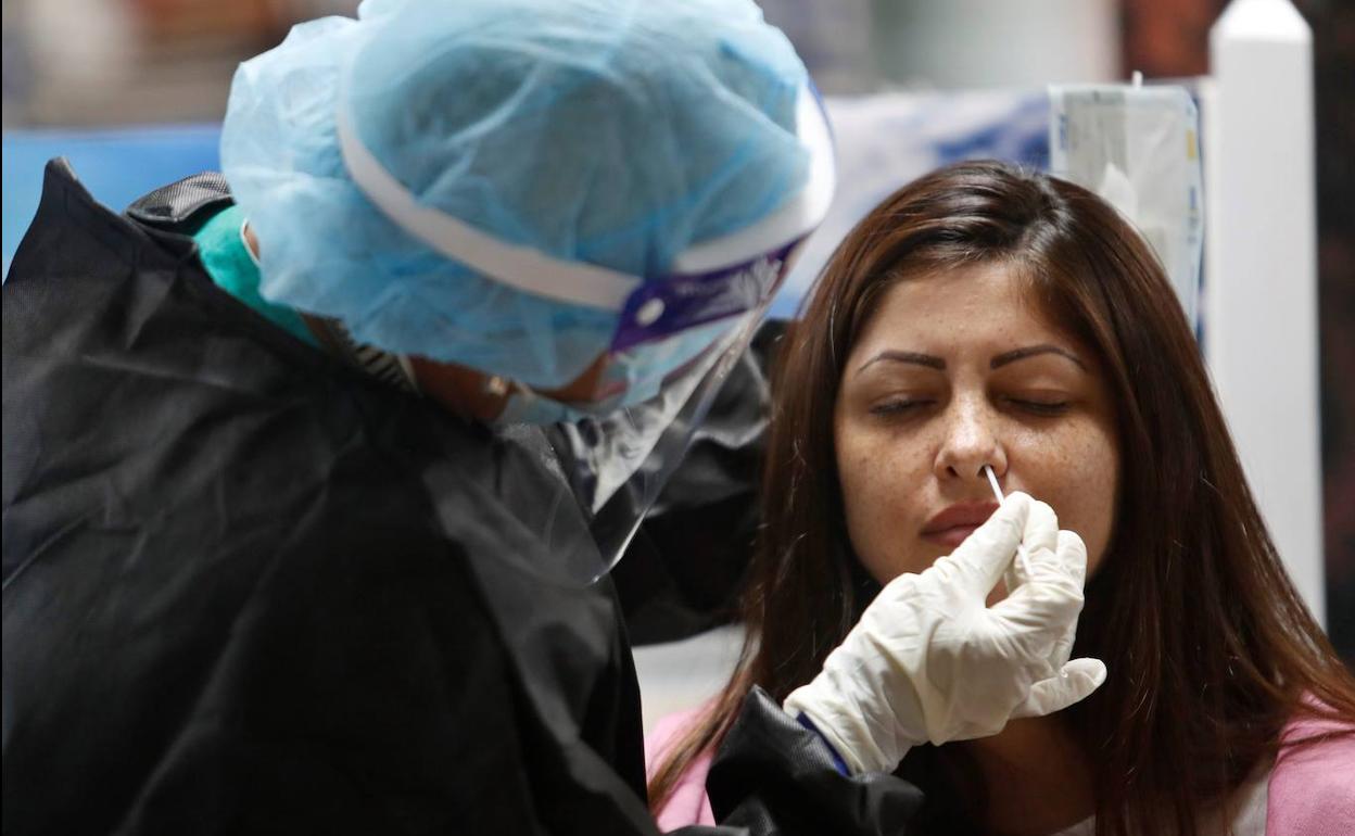 Un sanitario realiza una PCR a una posible paciente de Covid-19.