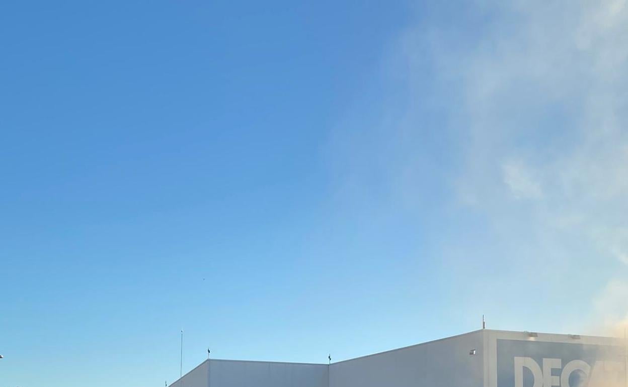 Los bomberos extinguen el incendio en el Decathlon de Alicante. 