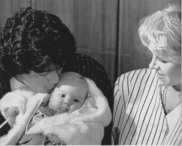 Maradona junto a su mujer, Claudia Villafane, besando a su hija Dalma, en 1989.