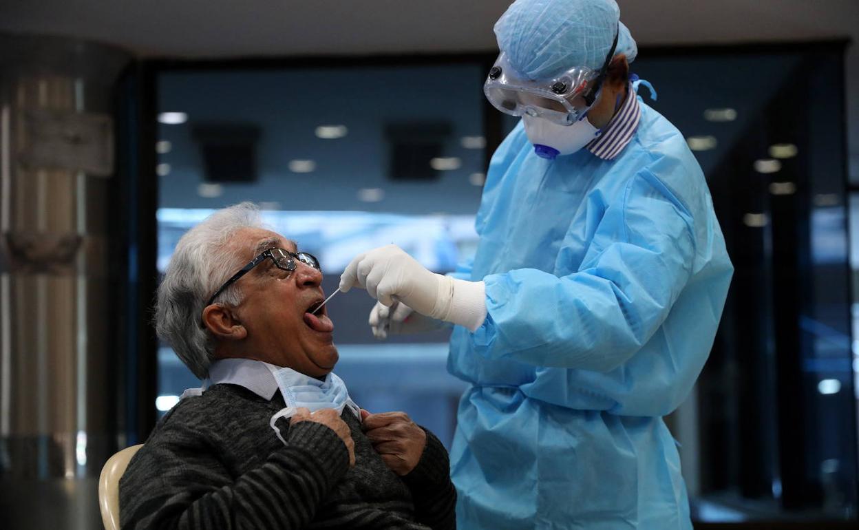 Un sanitario realiza una prueba PCR.