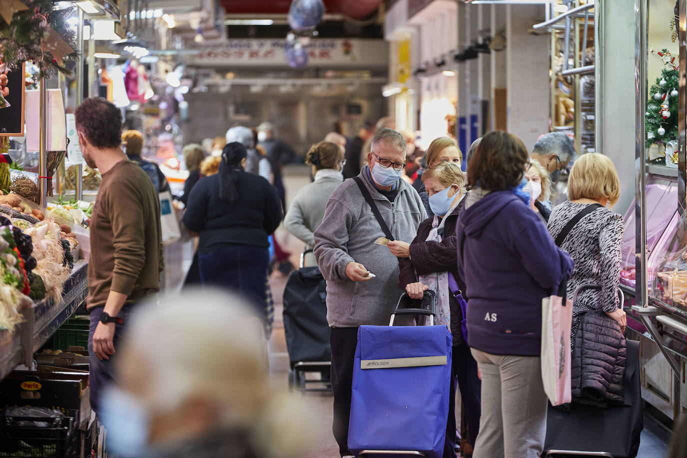 Con la Navidad a la vuelta de la esquina, los valencianos aprovechan para disfrutar del ambiente y realizar las compras en los mercados de la ciudad. La celebración de las fiestas navideñas este año será atípicas y con restricciones por la pandemia del coronavirus. En imagen, el Mercado del Cabaynal este martes.