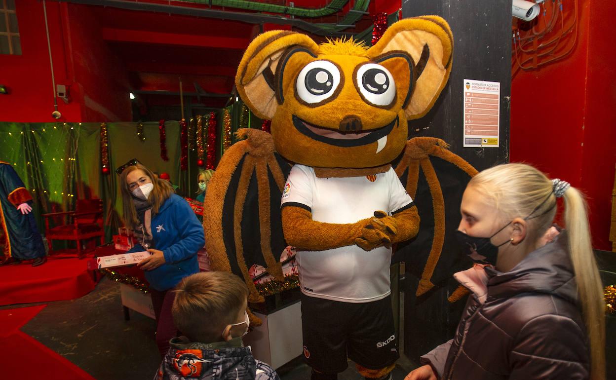 La mascota del Valencia, charla junto a uno de los niños que ha acudido a Mestalla. 