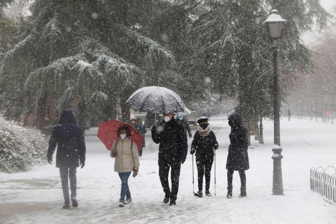 Varias personas paseando en el parque de El Retiro en el segundo día de nieve en la capital tras el paso de la borrasca Filomena, en Madrid.