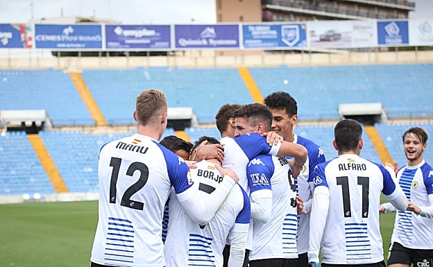 Los jugadores del Hércules se abrazan después de uno de los tres goles anotados este mediodía en el Rico Pérez. 