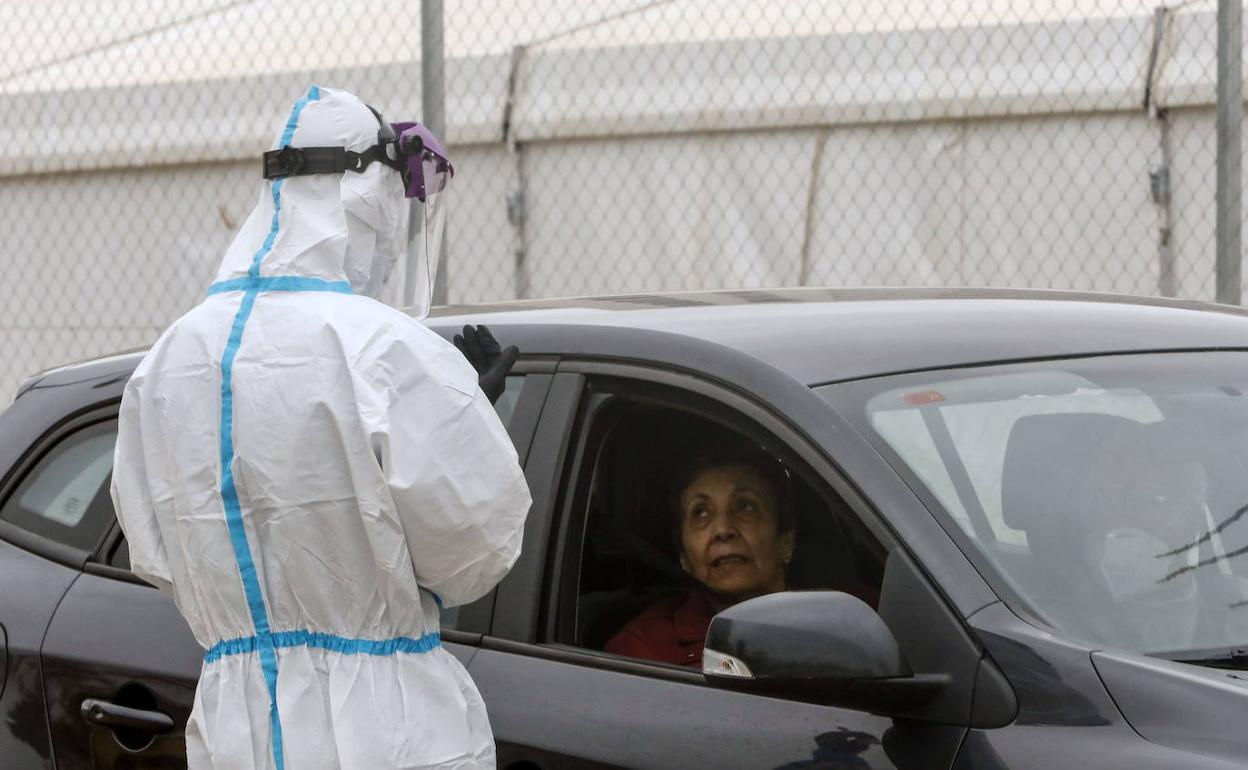 Un sanitario realiza una prueba PCR a las puertas de La Fe de Valencia.