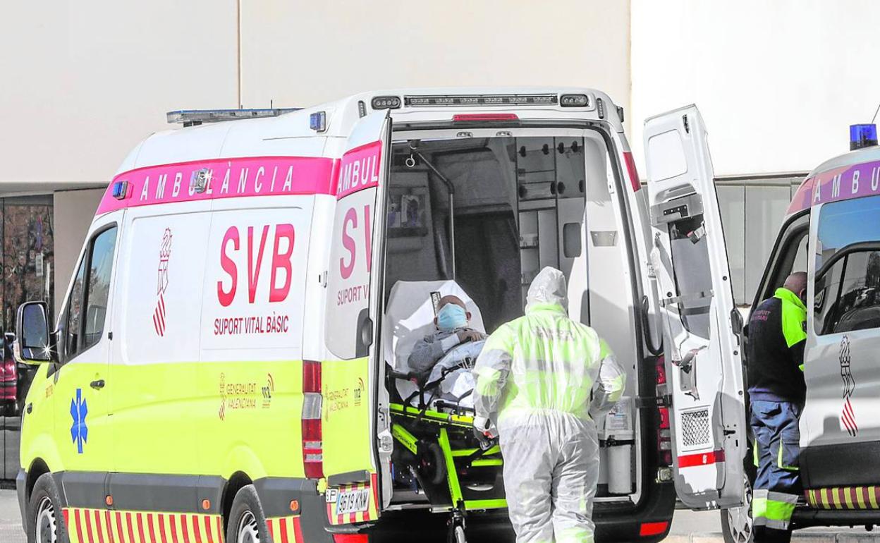 Un sanitario introduce a un enfermo en una ambulancia. 