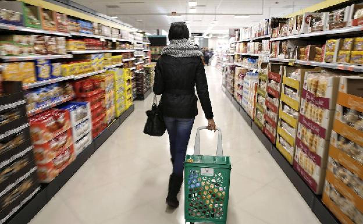 Una mujer con un carro en un supermercado.