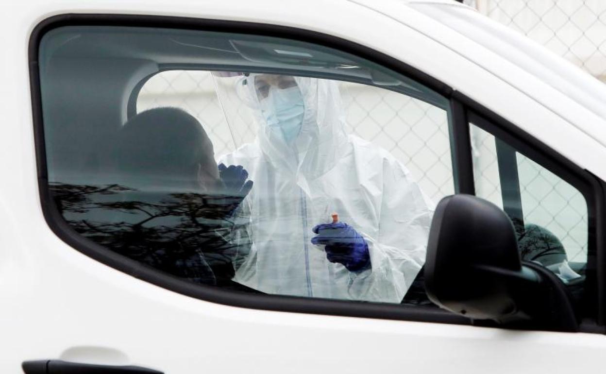 Personal sanitario realiza una prueba PCR ante el Hospital La Fe