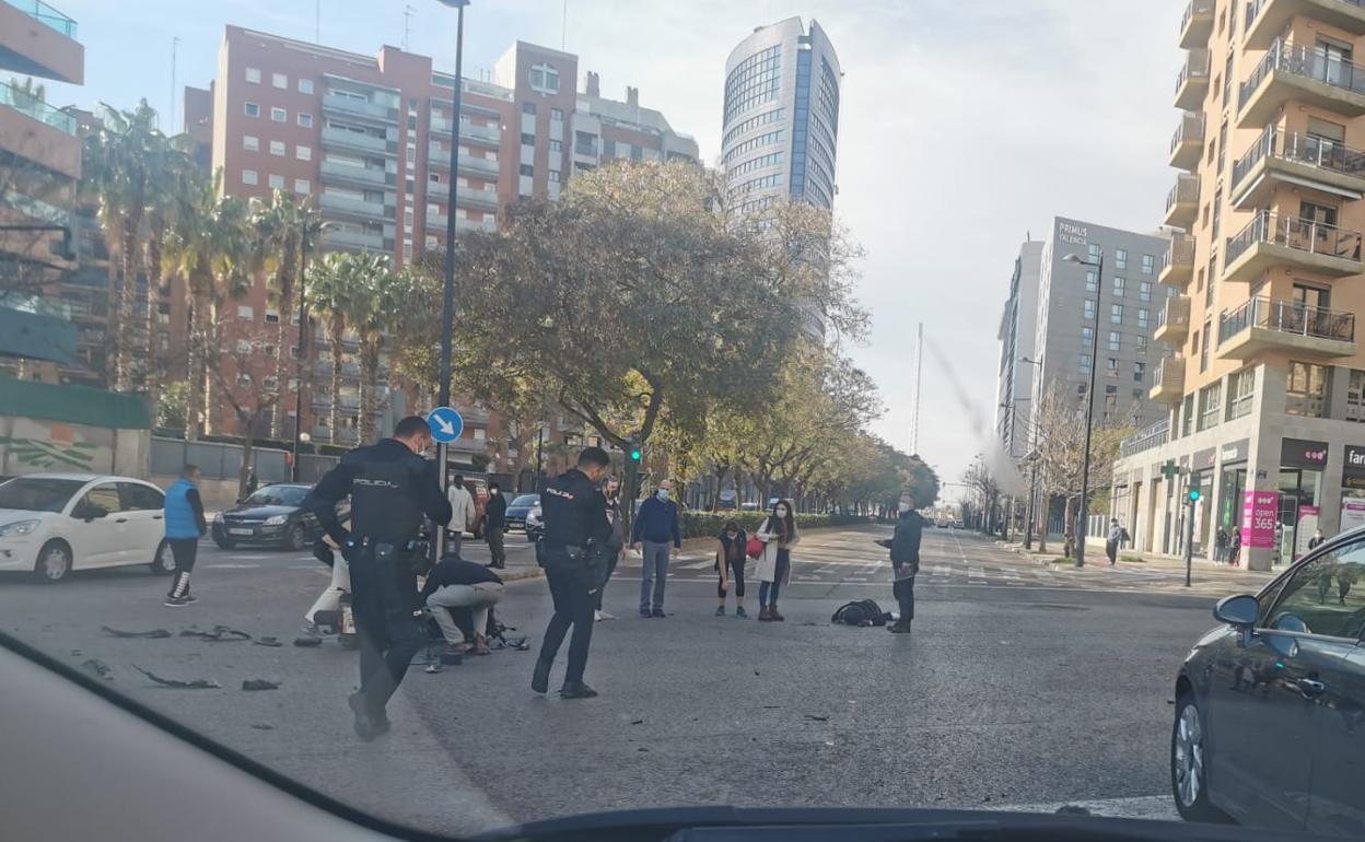 Varios vecinos y dos policías auxilian a la víctima en la avenida de Francia. 