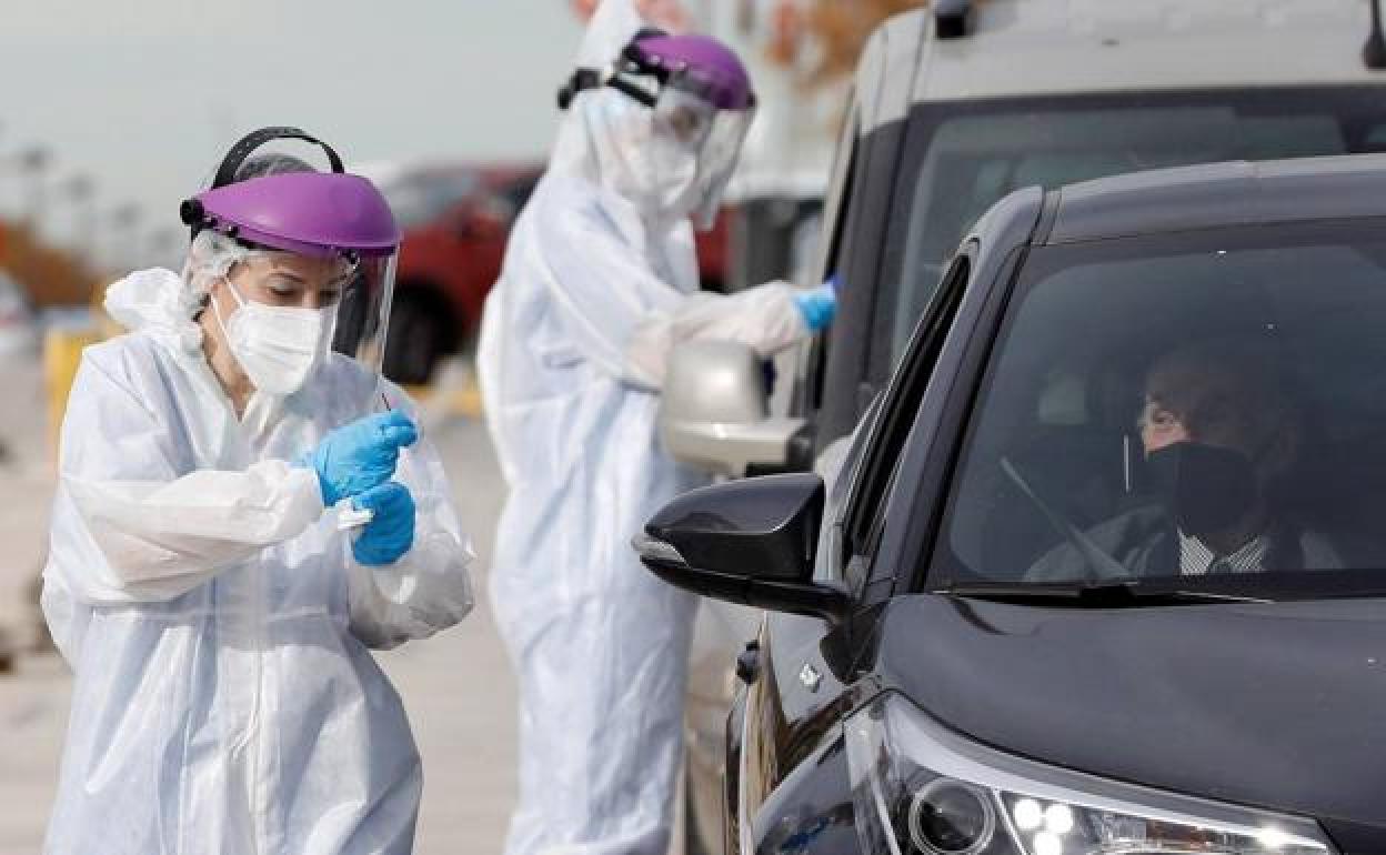 Dos sanitarios realizan PCR a las puertas del hospital de campaña de La Fe.