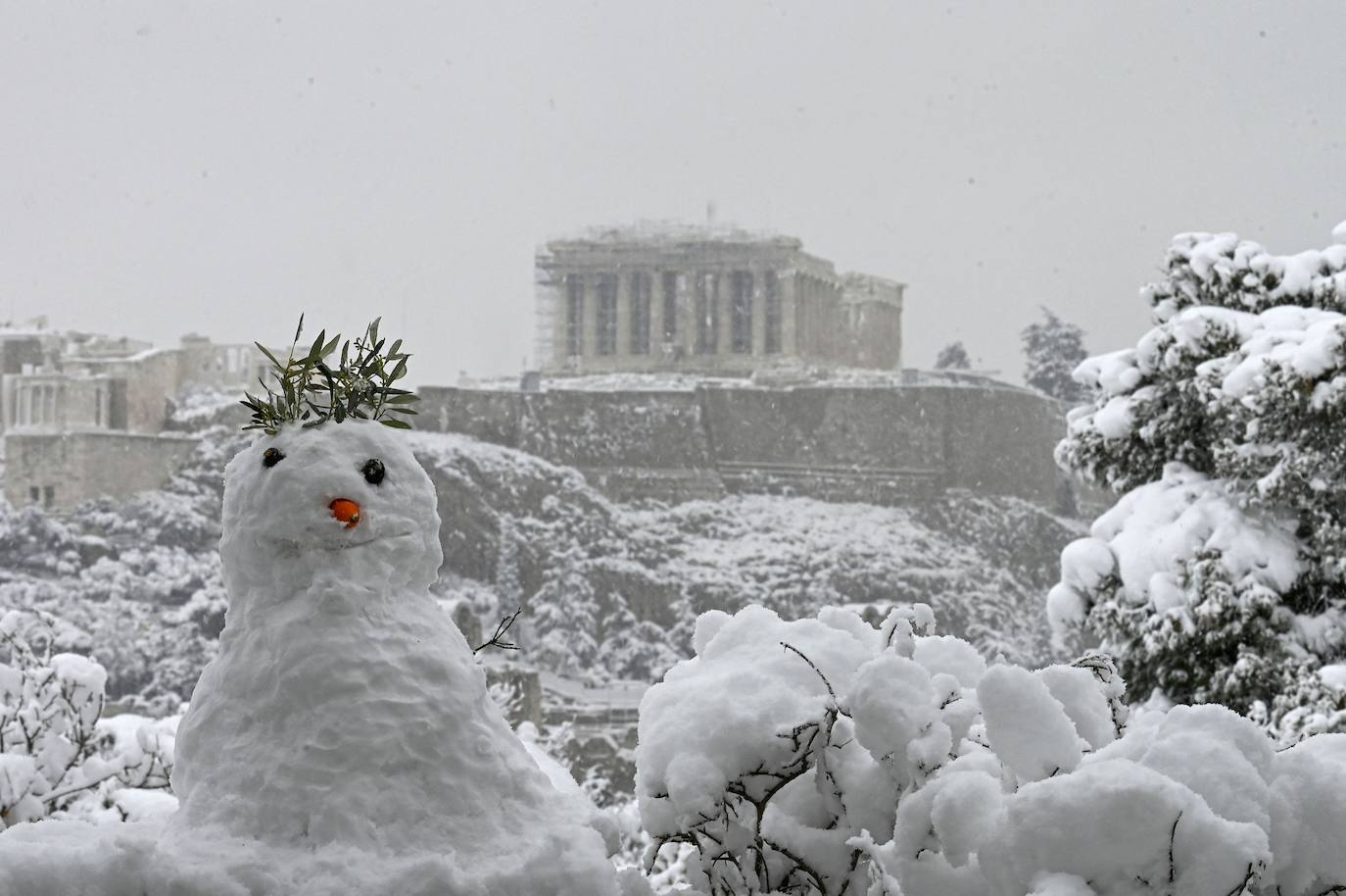 La Acrópolis de Atenas se despertó este martes bajo un manto de nieve al igual que otros monumentos de la antigüedad en la capital griega, ofreciendo un espectáculo excepcional en medio de la ola de frío 'Medea' que afecta al país. El Partenón, el célebre templo del siglo V antes de nuestra era, en lo alto del peñasco en el centro histórico, apenas podía verse a raíz de la nieve que cayó en la noche.