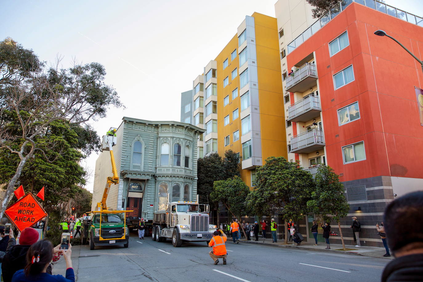 Y todo este lío, a cuento de qué. La explicación es sencilla. En el solar donde estaba la casa se construirá un edificio de apartamentos de ocho pisos. La casa rodante encontrará asiento al lado de una antigua funeraria. 