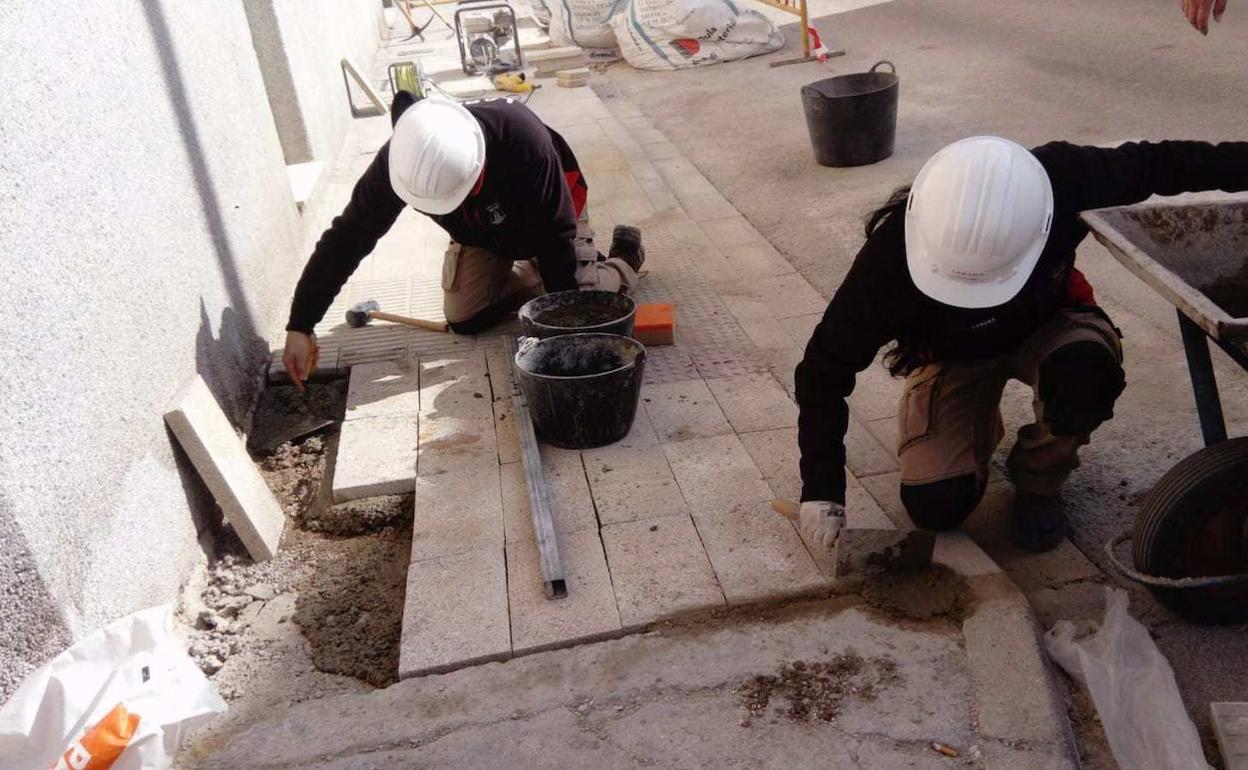 Dos alumnos del taller de ocupación trabajando en la vía pública. 