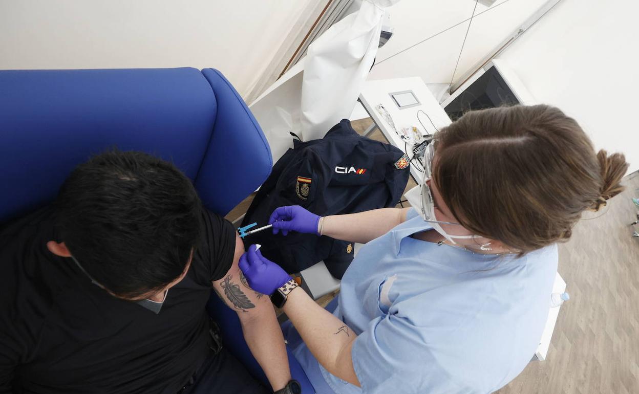 Personal sanitario vacuna a un agente de policía en el hospital de campaña de Valencia.