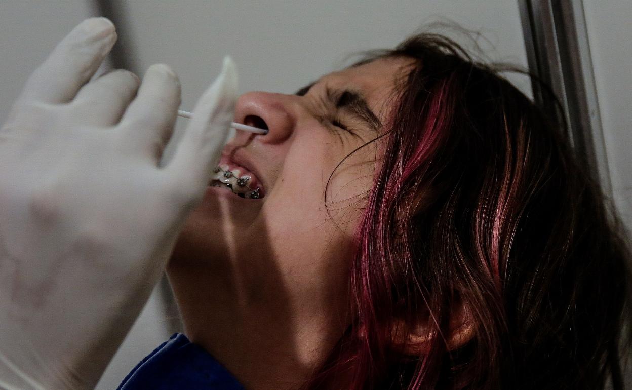 Un sanitario realiza una PCR a una ciudadana brasileña. 