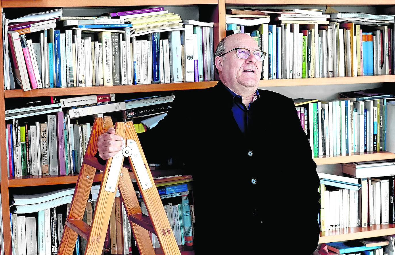 José Luis Villacañas posa ante la bien nutrida biblioteca de su casa.