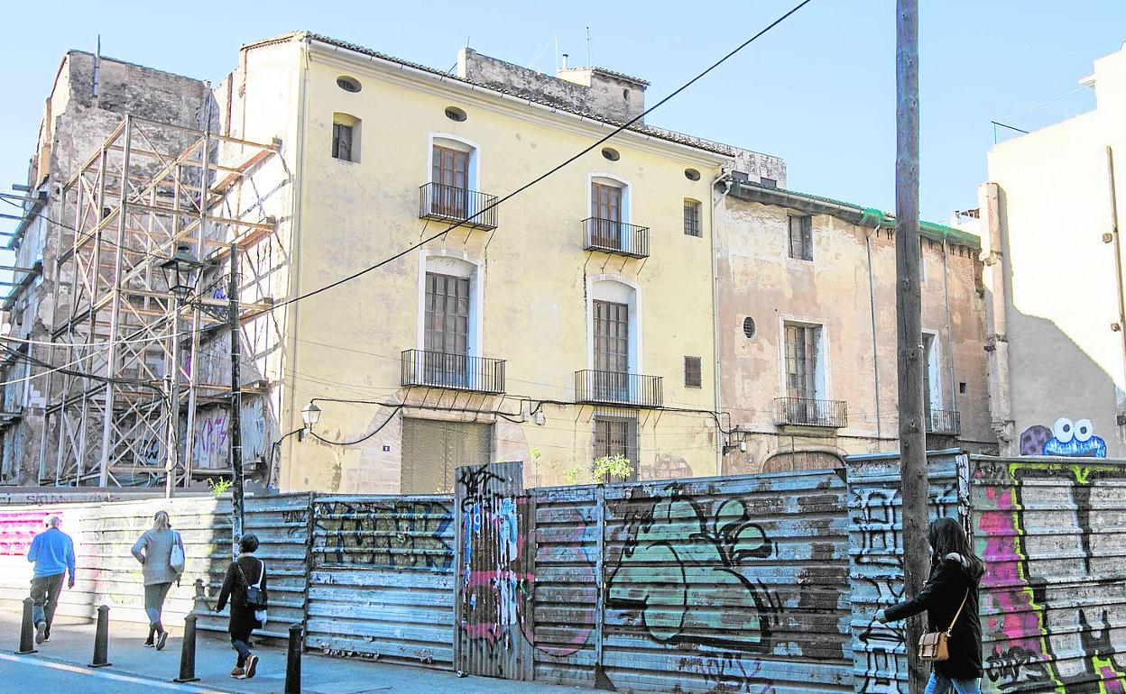 Edificios pendientes de rehabilitar al fondo de la imagen. 