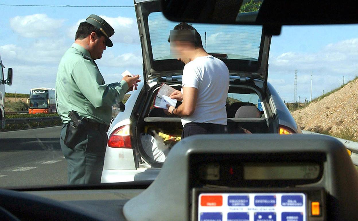 Un agente de la Guardia Civil impone una multa a un conductor. 