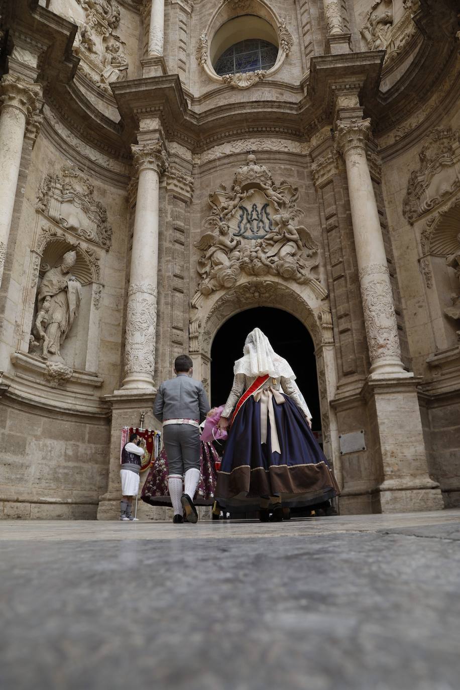 Decenas de personas acuden a la misa de la Catedral y también vestidas de fallera a la Basílica de la Virgen