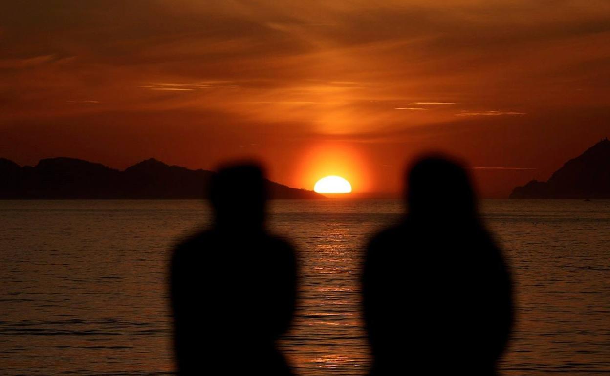 Una pareja observa una puesta de sol