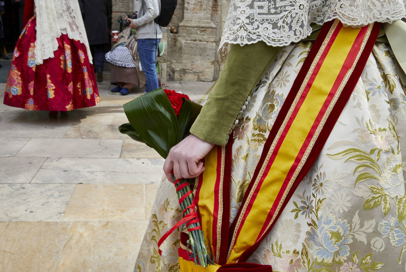 Decenas de personas acuden a la misa de la Catedral y también vestidas de fallera a la Basílica de la Virgen