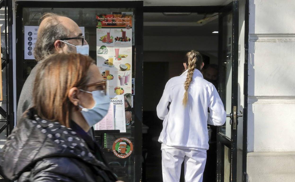 Personas paseando en Valencia con mascarilla. 