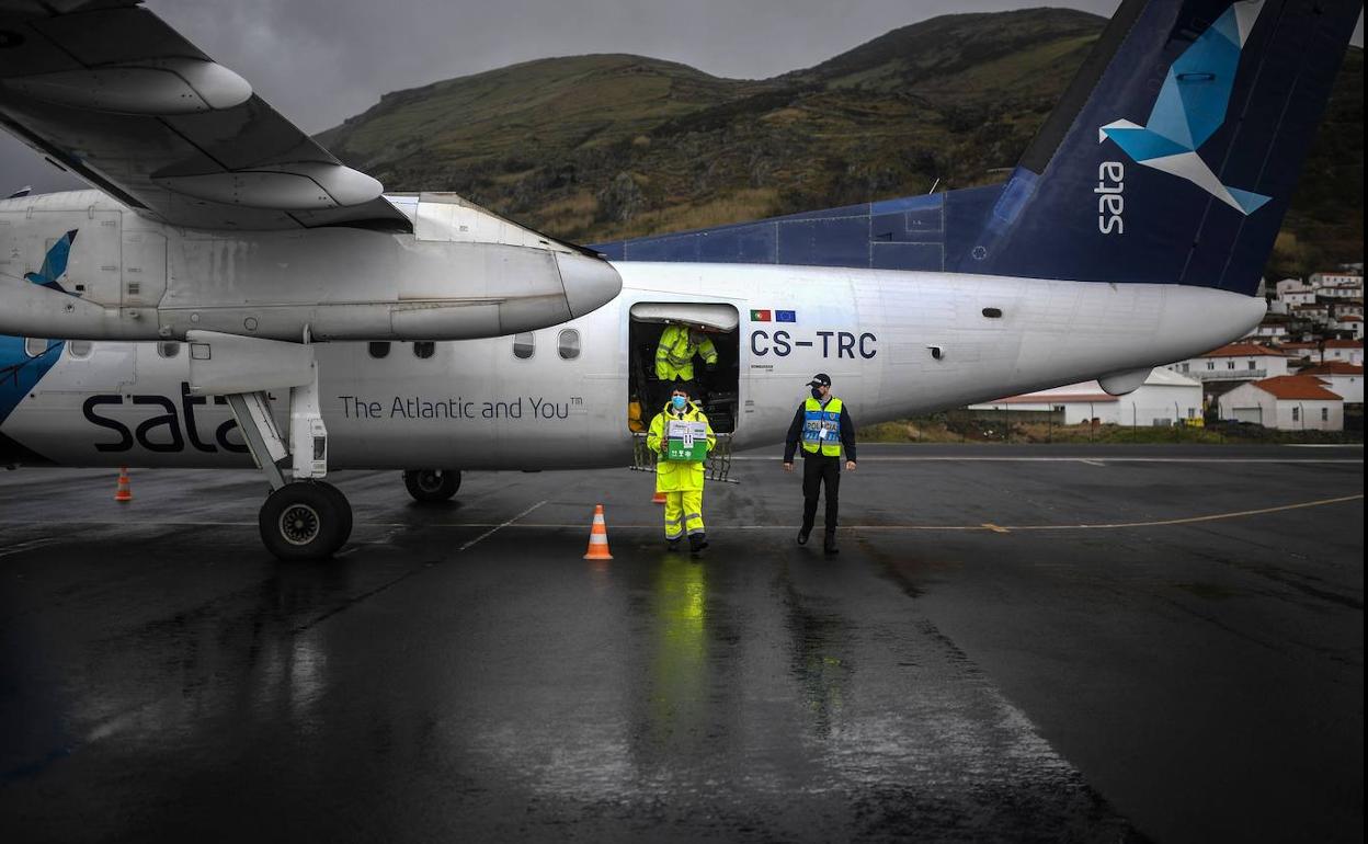 Personal técnico descarga vacunas contra la covid en un aeropuerto de las islas Azores.