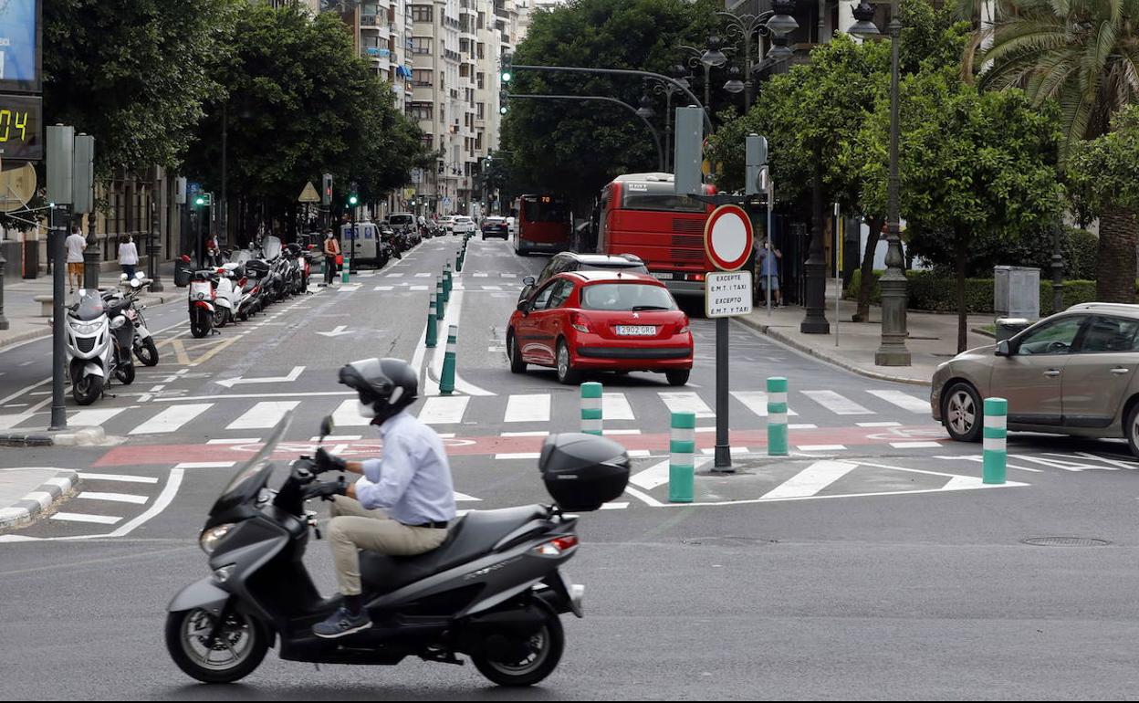 Un hombre circula en moto por Valencia