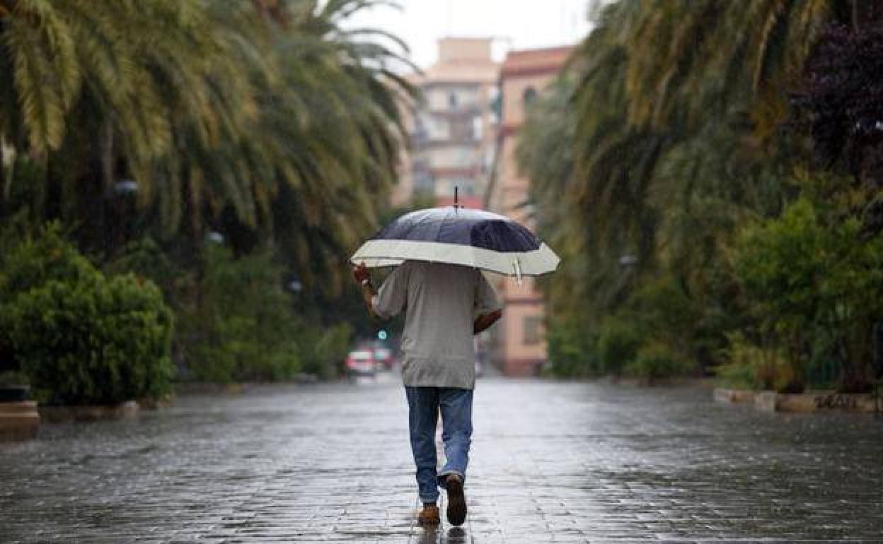 Un hombre se protege de la lluvia en Valencia