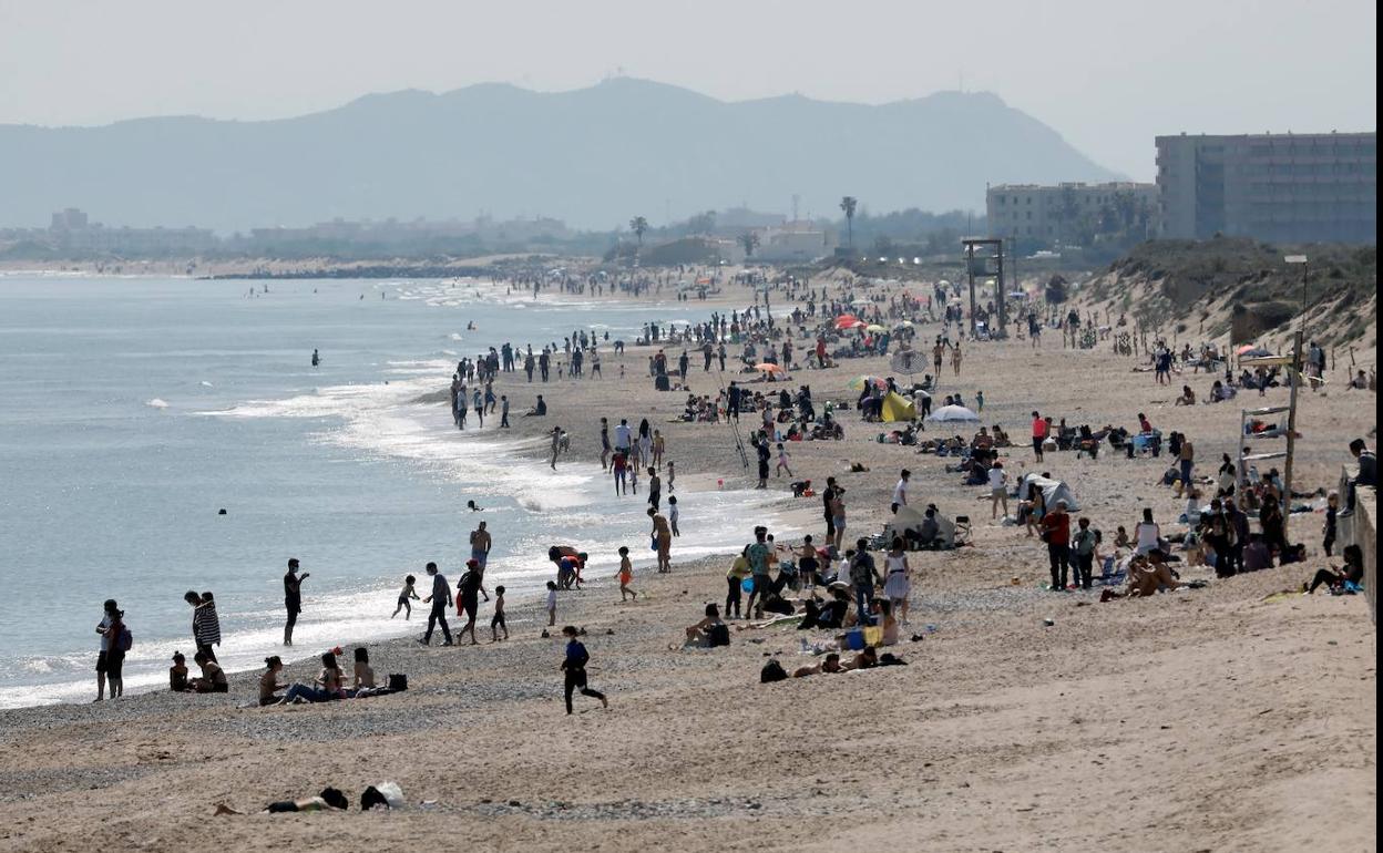 Cientos de personas pasean y toman en sol en las playas de la Dehesa de El Saler, en Valencia. 