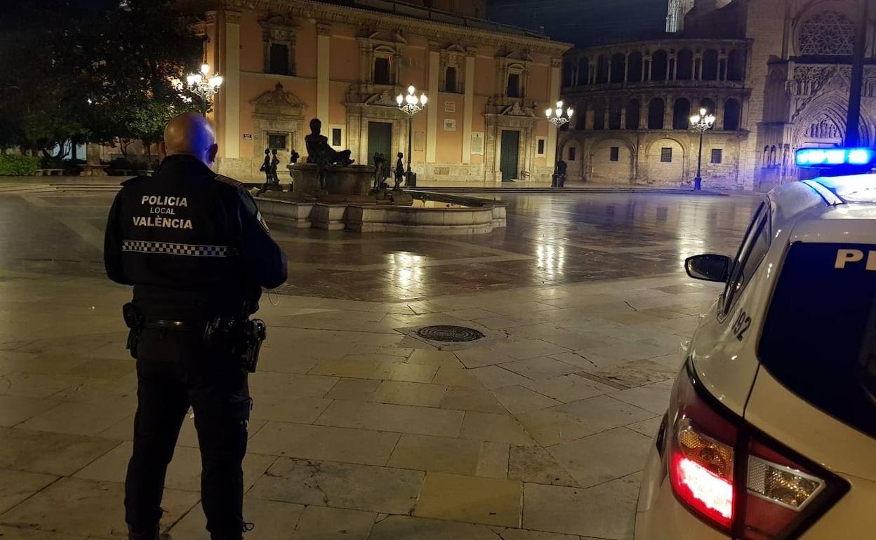 Un policía local vigila la plaza de la Virgen de Valencia.