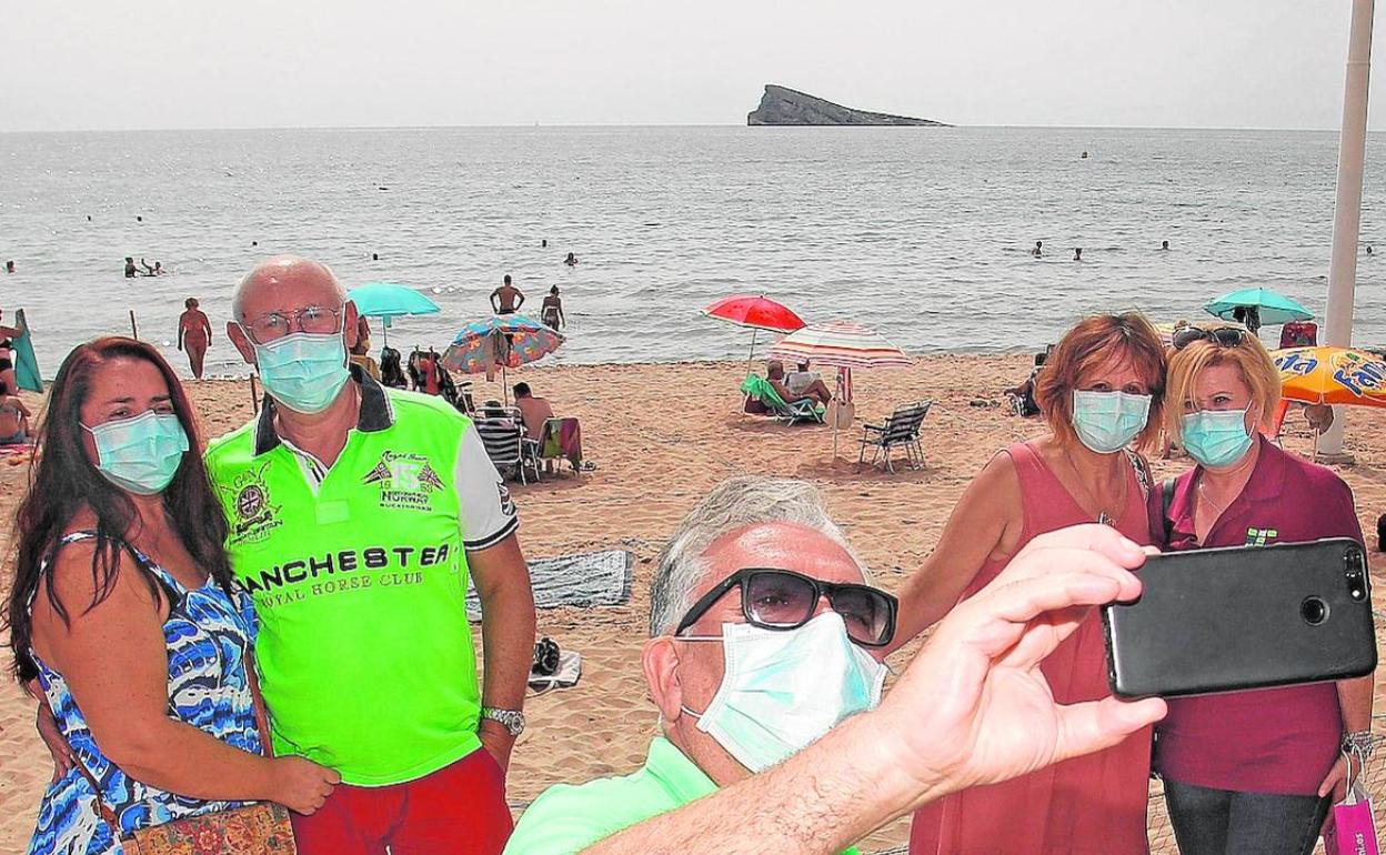 Los miembros de ACUMAFU (Asociación Cultural de Mayores de Fuenlabrada) que han organizado su viaje a la capital de la Costa Blanca tras la suspensión del programa de viajes del IMSERSO paseando por la playa de Levante de Benidoprm. 