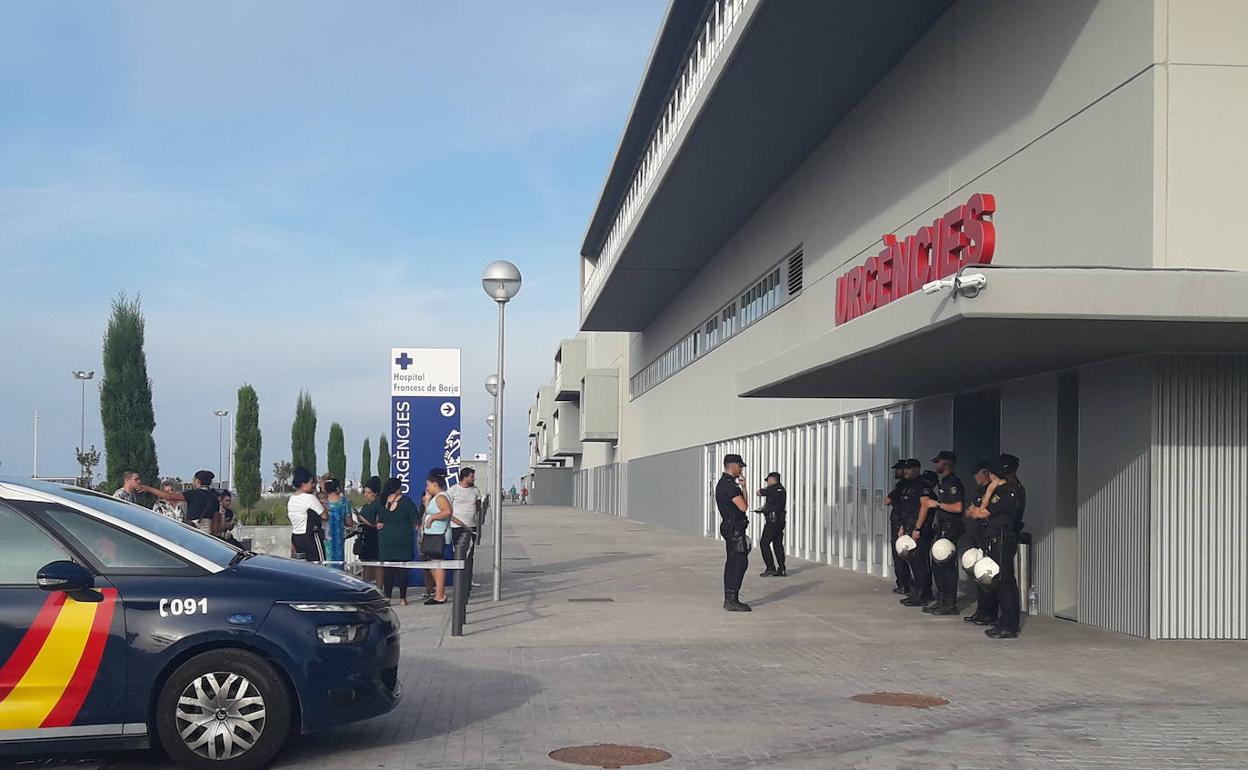 Dispositivo policial en la puerta de urgencias del Hospital de Gandia, junto a familiares de las víctimas en una zona precintada. 