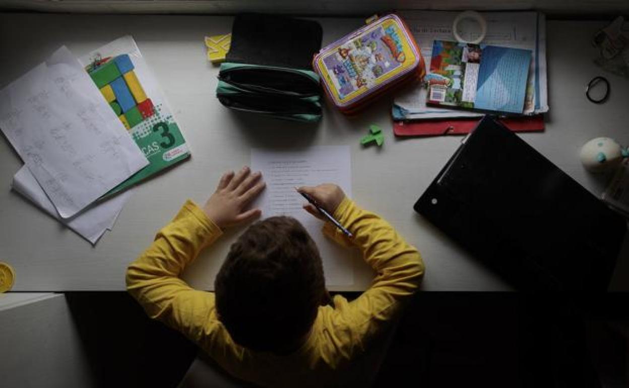 Un niño realiza tareas escolares. 