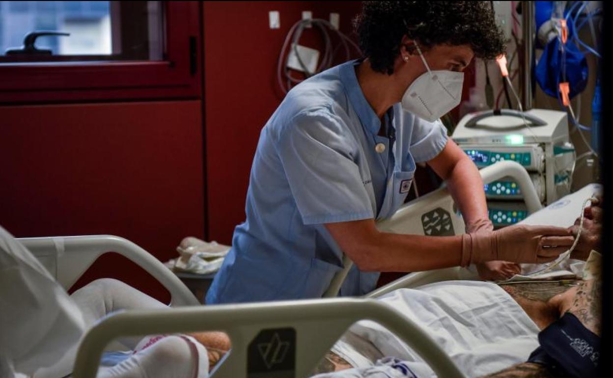 Una sanitaria atiende a un paciente de covid en el hospital vizcaíno de Basurto.