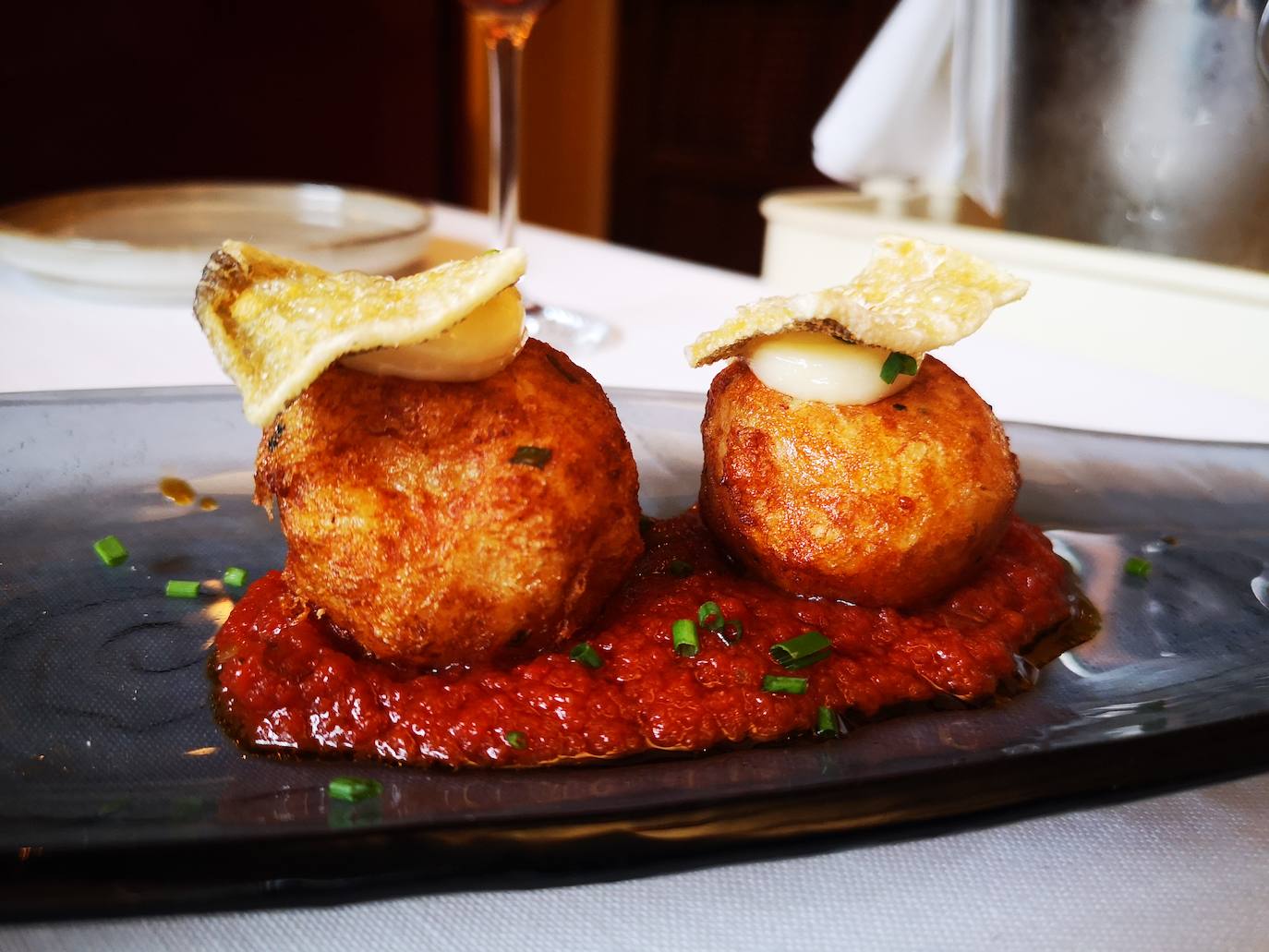 Sus croquetas de bacalao. Suaves, melosas, en su punto salino y sobre un lecho de pisto de pecado. 