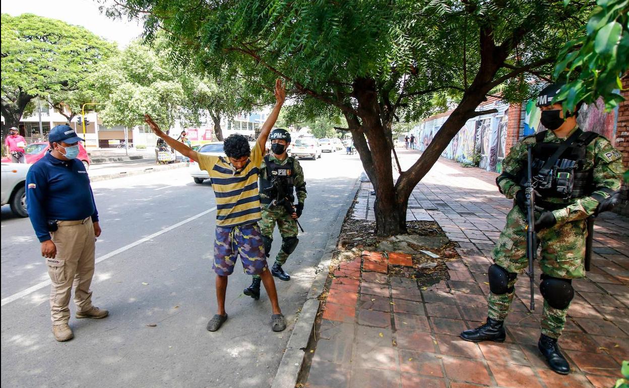 Un militar registra a un joven en Bogotá.