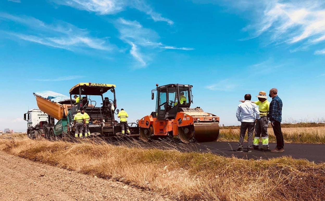 El alcalde, Paco Comes visita los trabajos de asfaltado en un camino. 