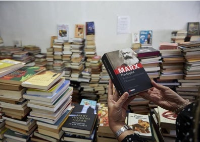 Imagen secundaria 1 - Alrededor de 10.000 libros han depositado en el Club de los Libros Libres. En la imagen se ve un ejemplar en alemán de 'El capital', de Marx y también las instrucciones para poder rescatar libros del cementerio. 