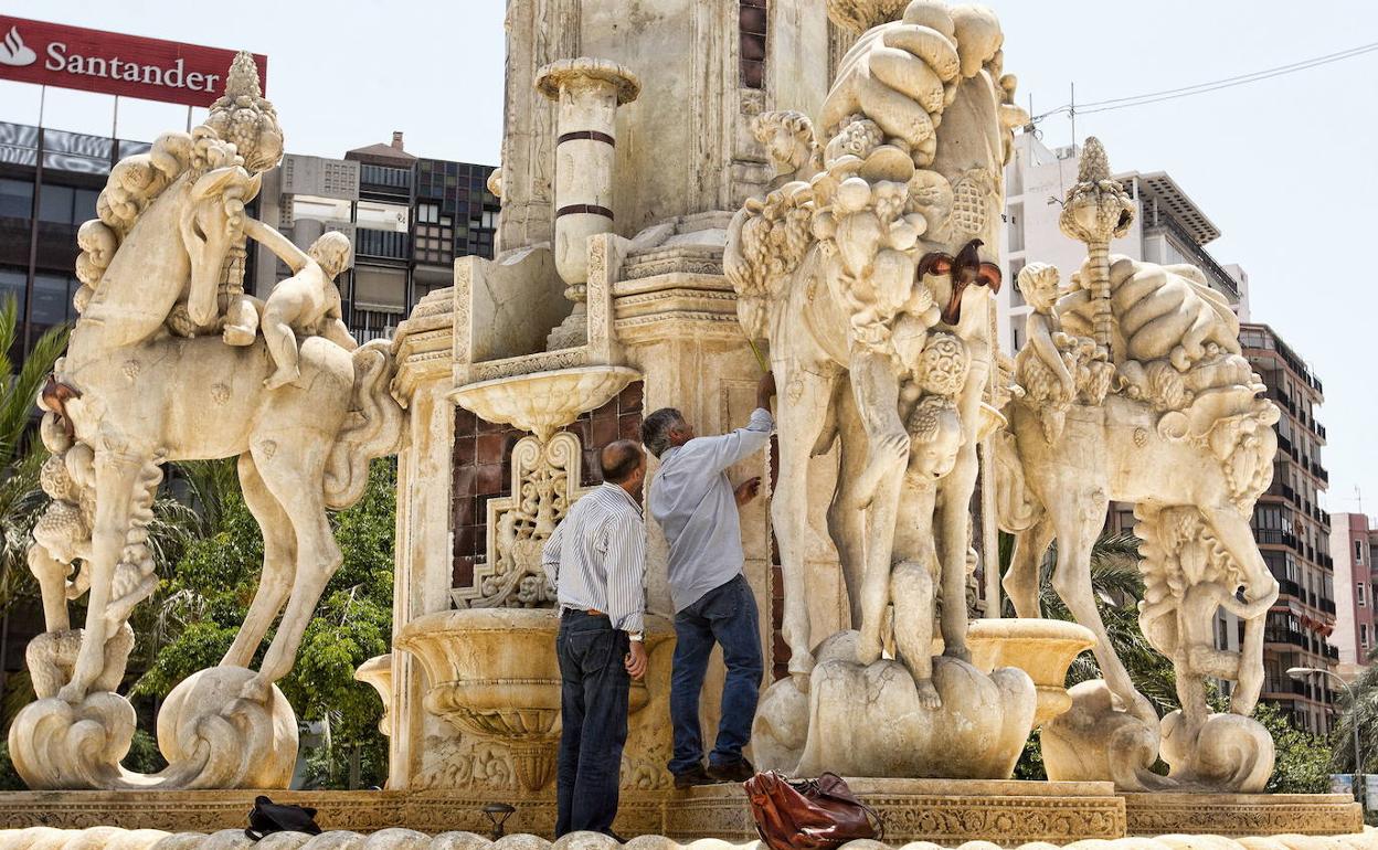 Dos técnicos realizan comprobaciones en las figuras de la fuente de la Plaza de los Luceros. 