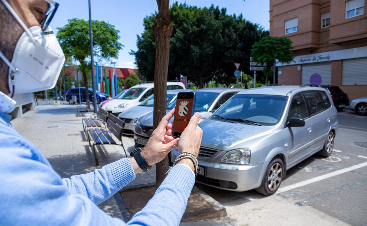 Una persona utiliza la aplicación móvil que detecta las plazas de aparcamiento libres. 